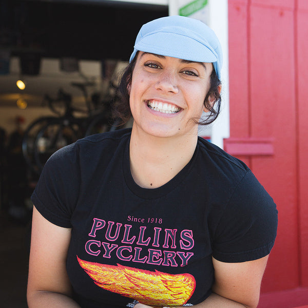 Smiling woman wearing blue technical 4-panel cap.