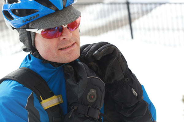 Man wearing an ear flap cap under a helmet in winter.