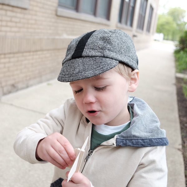 Child wearing the Buckaroo kids cap and playing with a toy airplane.
