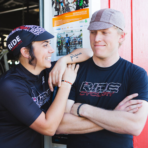 Man and woman wearing Walz caps in front of bike shop.